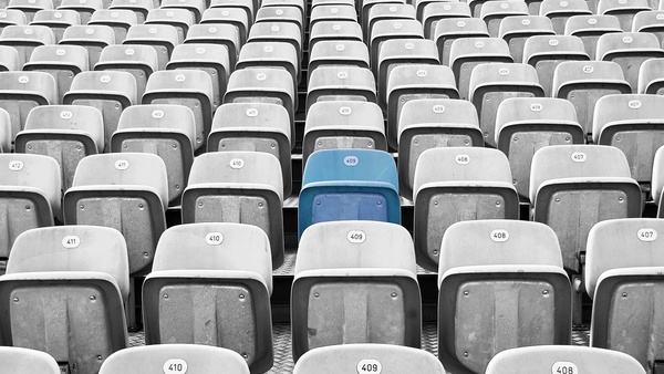 Blauer Stadionsitz umgeben von grauen Sitzen